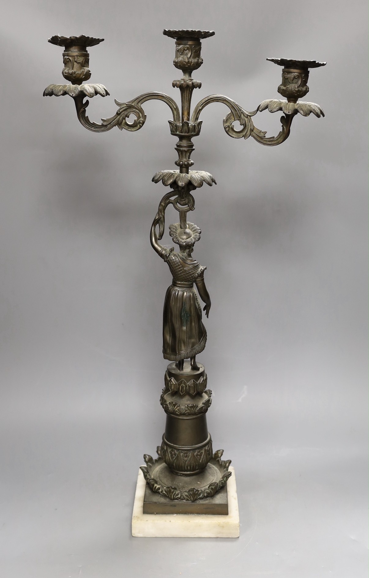 A bronzed spelter figural three light candelabrum, 60cms high